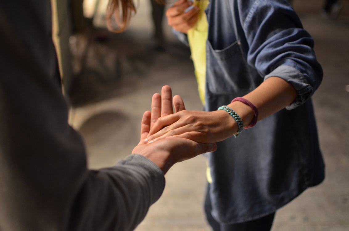 Person, die einer anderen helfend die Hand reicht