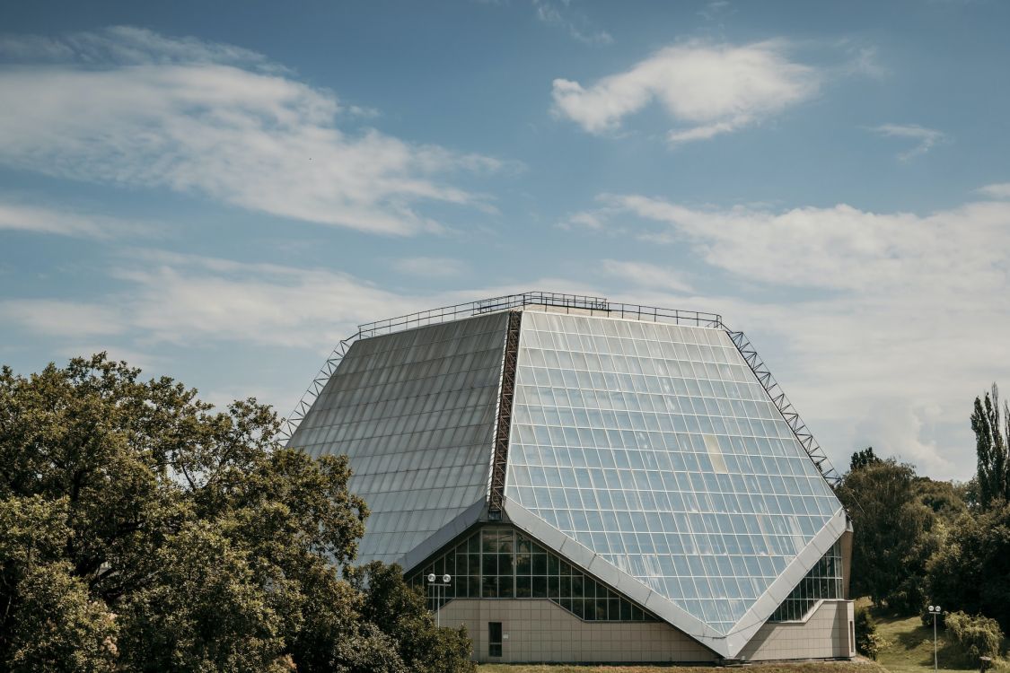 Futuristisches Gebäude, dessen Dach bis an den Boden reicht und komplett als Solarpanelen besteht.