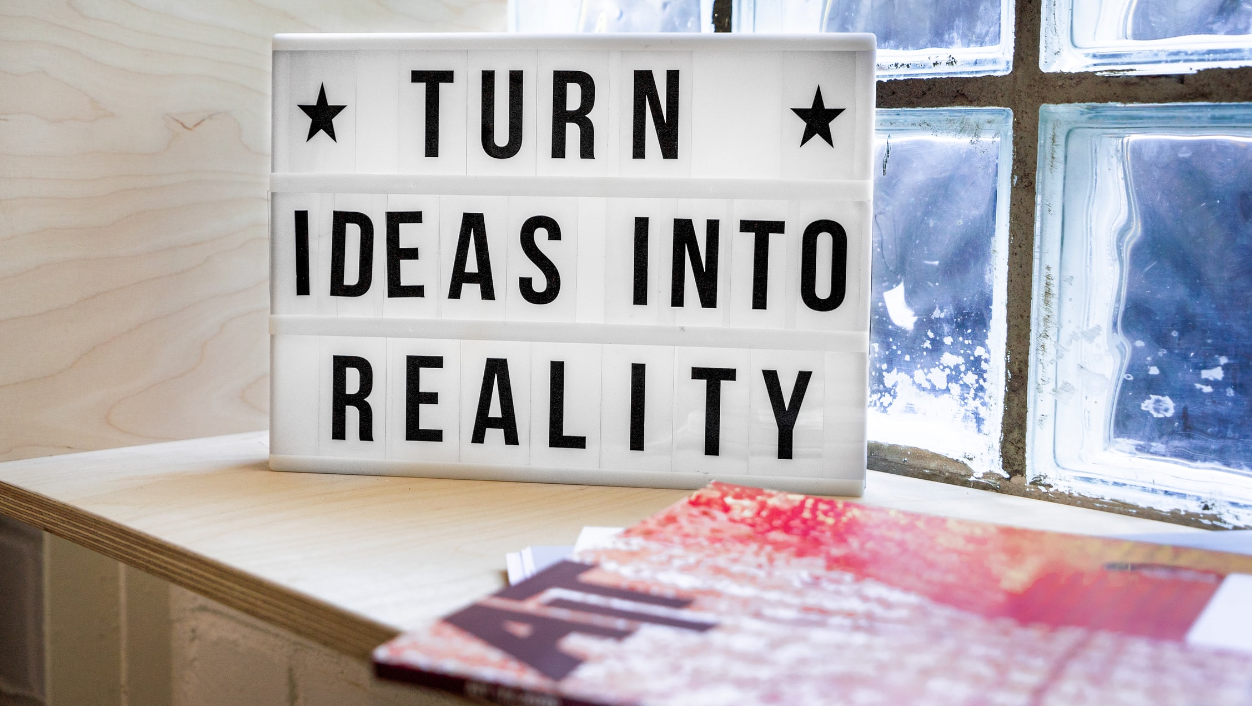Board mit der Aufschrift: "TURN IDEAS INTO REALITY"