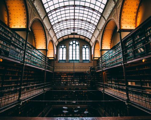Bücherei in einem alten, schönen Gebäude, Fenster in der Mitte, links und rechts Regale voller Bücher