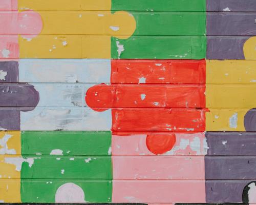 Wand mit bunten Puzzleteilen bemalt