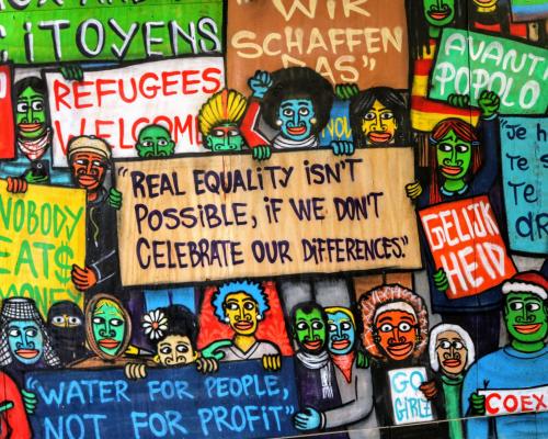 Buntes Wandgraffitti mit den Aufschriften "Refugees welcome" und "Real equalitiy is not possible if we don't celebrate our differences".